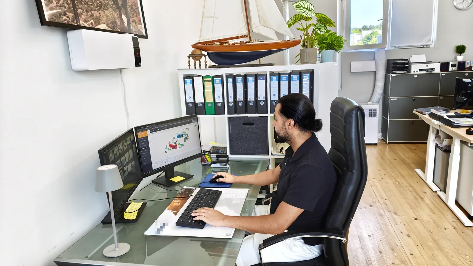 Sachverständiger bearbeitet eine Schadenkalkulation am Doppelmonitor im Büro