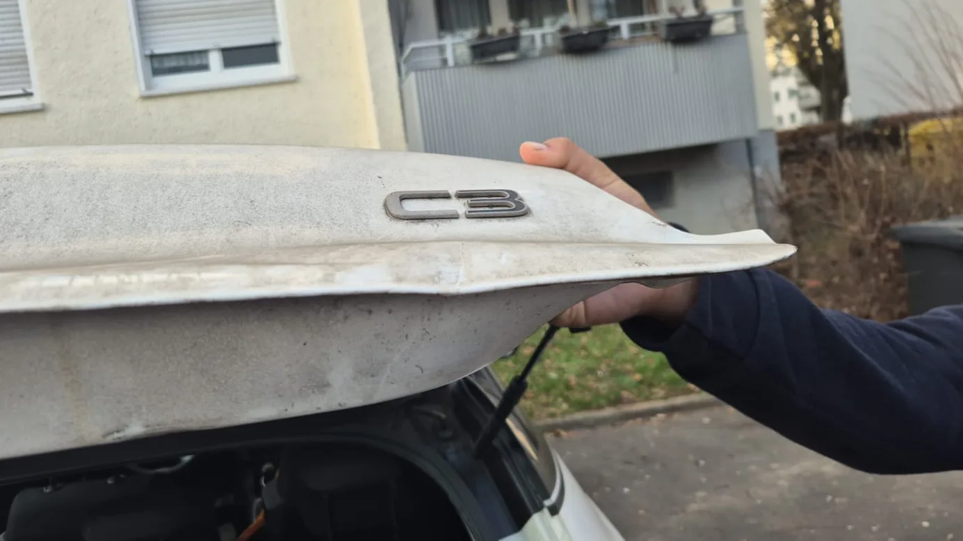 Angehobene Motorhaube eines Kleinwagens mit über die ganze Breite verzogener Vorderkante